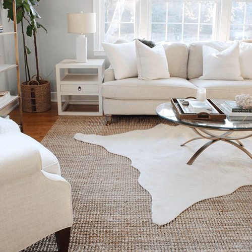 Layering neutral rugs in a neutral-colored room with minimalist decor