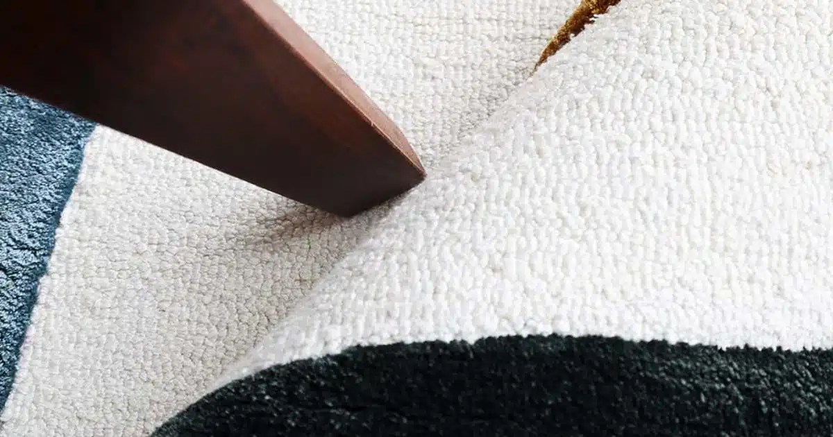 A close-up view of a wrinkled fixing carpet ripples being smoothed out by a professional flooring tool